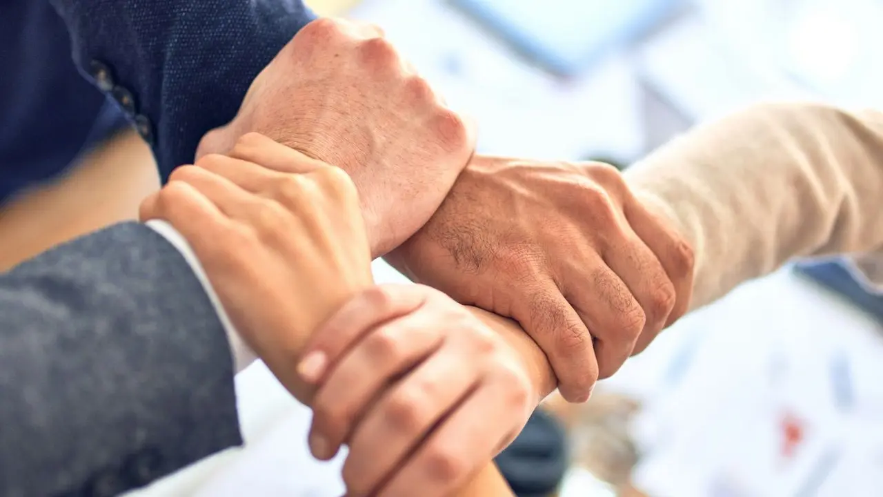 person in black long sleeve shirt holding persons hand